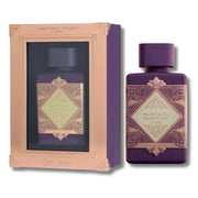 Amritayy Fusion Lila fragrance shown with its purple bottle and a matching gift box. The bottle and box feature a deep purple body with a metallic rose gold geometric frame and a light green diamond-shaped label.